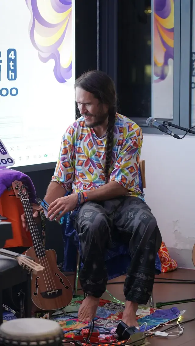 A seated musician with a small stringed instrument at ShanHaiWoo.